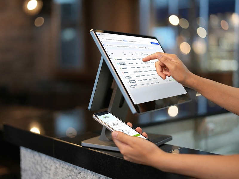 Quelqu'un utilisant un logiciel de caisse avec un téléphone dans la main gauche