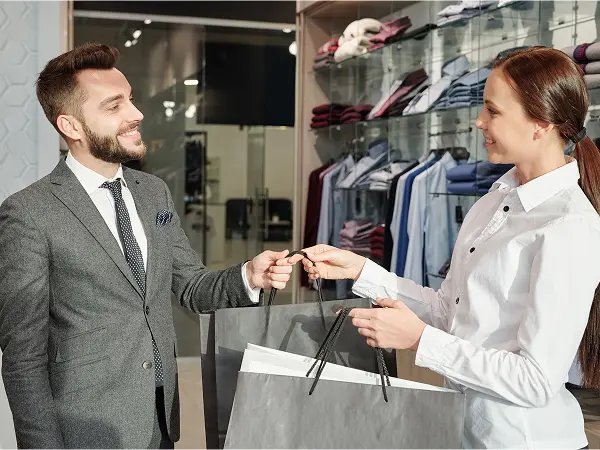 Un vendeur remettant des sacs à un client