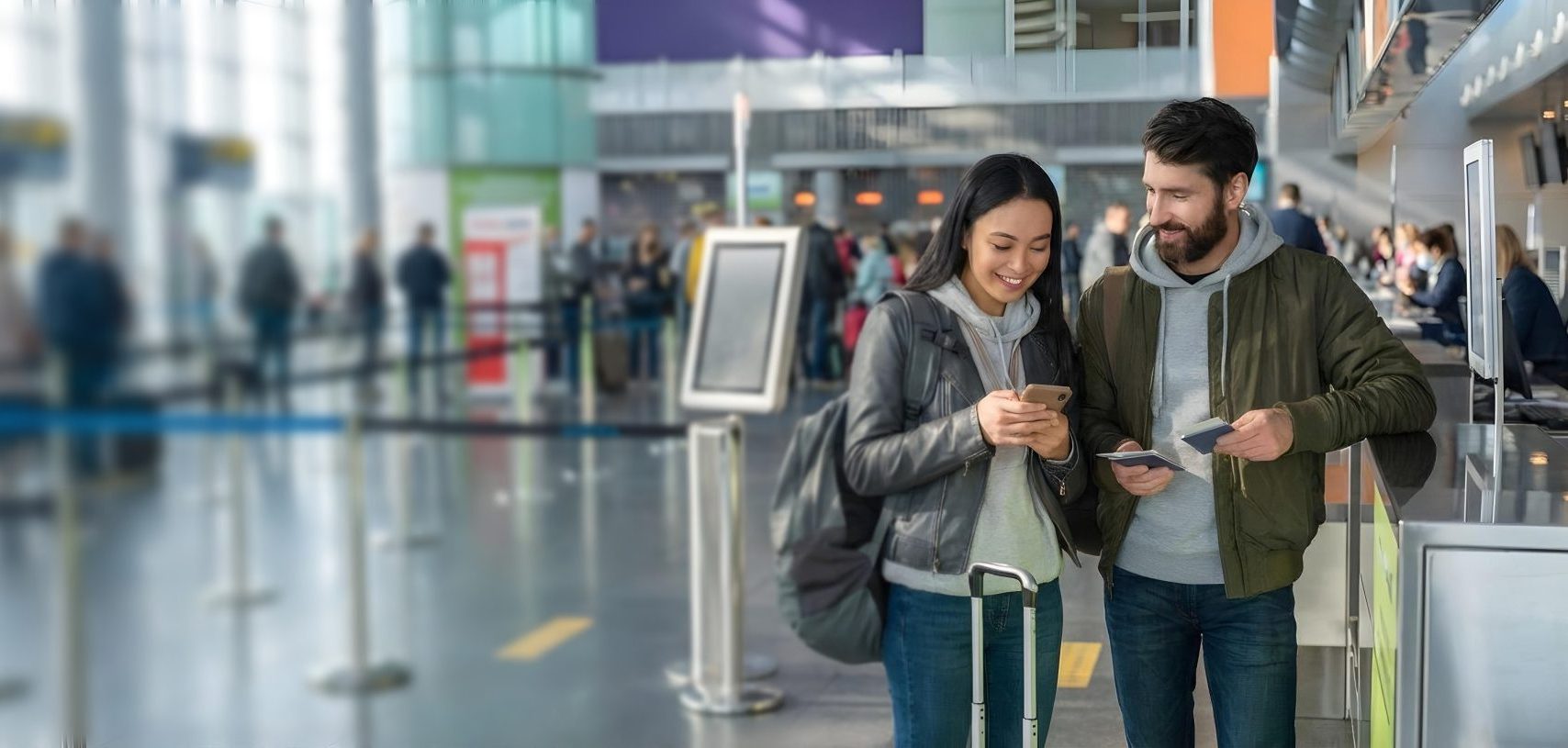 Deux voyageurs consultant leurs téléphones dans un aéroport